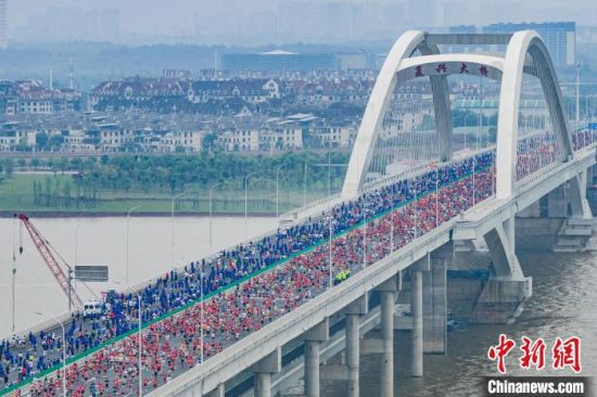 图为江铃控股·2024南昌象湖半程马拉松参赛选手奔跑在南昌复兴大桥上。主办方供图